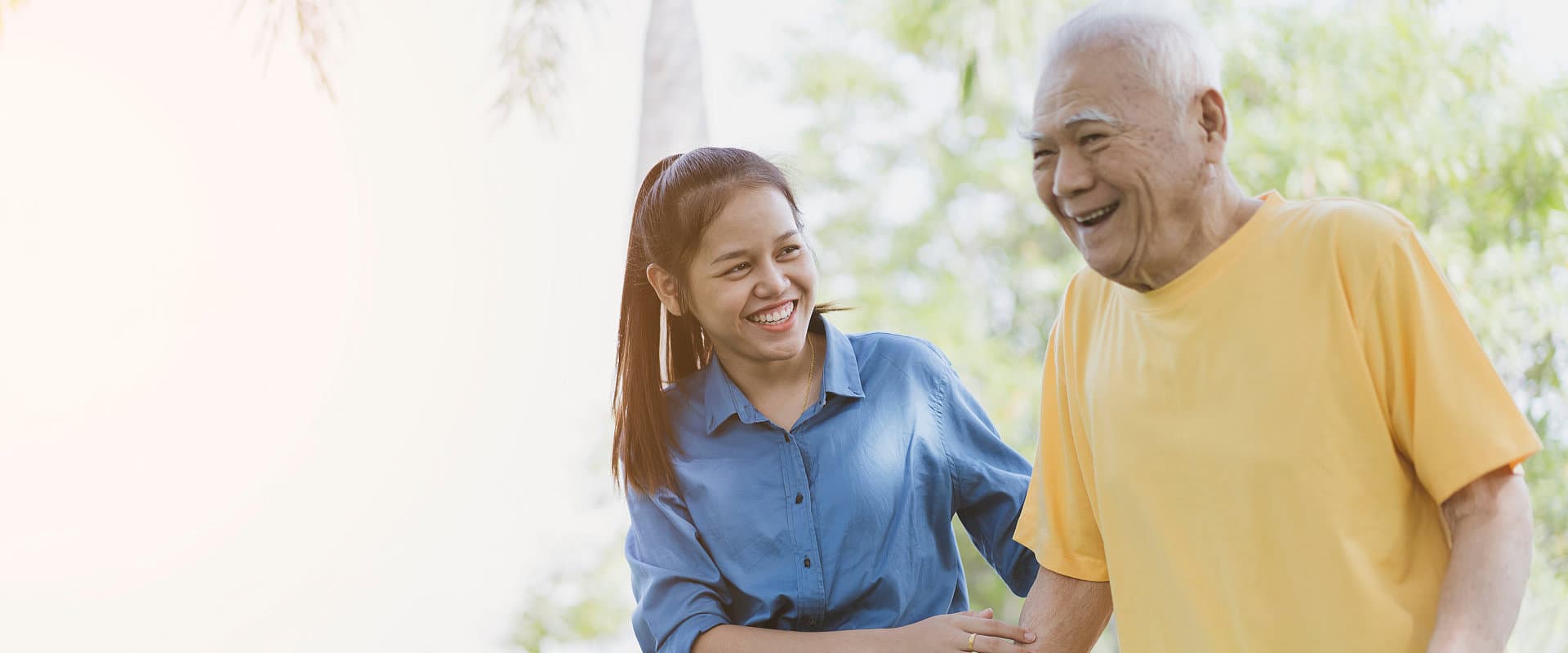 elderly man and caregiver woman smiling