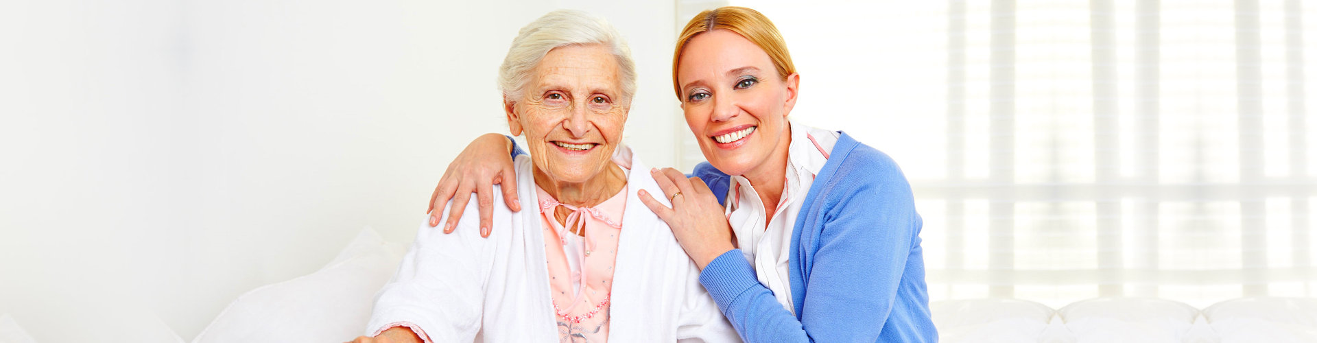 a caregiver and senior woman smiling