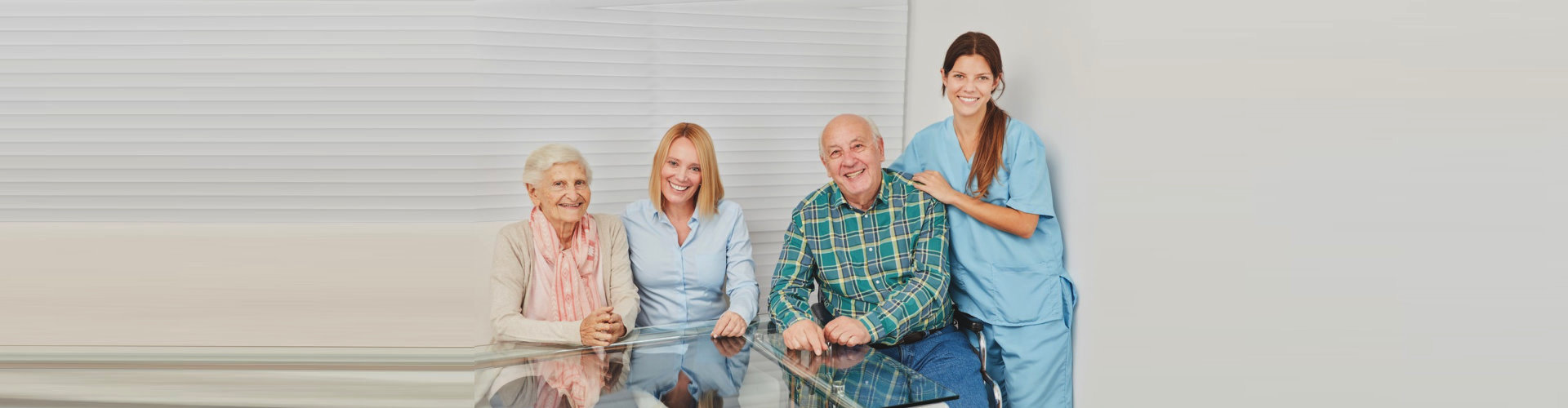 two seniors and two caregivers smiling
